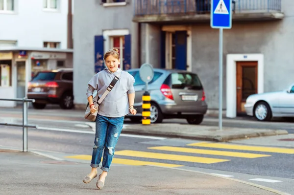 Счастливая 9-летняя школьница с рюкзаком на улицах города — стоковое фото