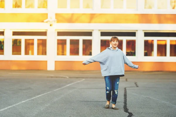 Leuk 9-jarige jongen meisje spelen op het schoolplein, het dragen van denim jeans en grijze sweater — Stockfoto