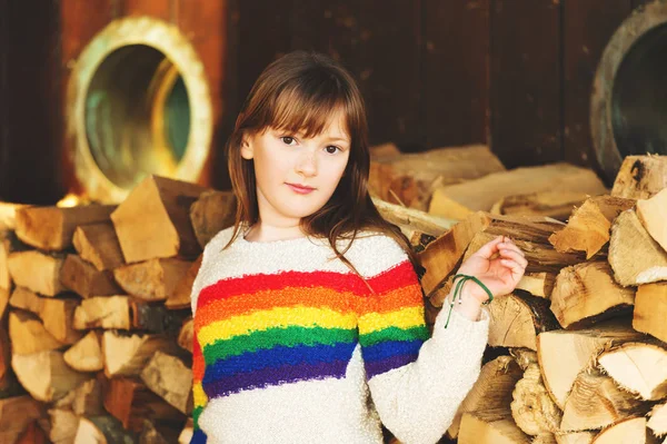 Utomhus porträtt av ganska 9-årig flicka poserar utomhus, bär färgglada pullover — Stockfoto