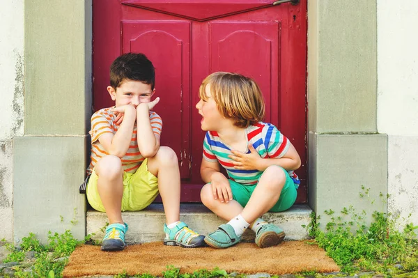 Группа из двух веселых маленьких мальчиков, играющих вместе на открытом воздухе, одетых в красочные футболки, шорты и обувь, летняя мода для детей . — стоковое фото