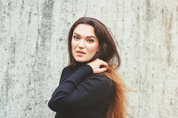 Outdoor portrait of young 35 year old woman with long dark hair, wearing black turtle neck dress — Stock Photo, Image