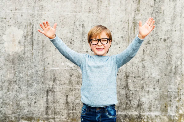 Ritratto all'aperto di un bambino carino che indossa occhiali, pullover azzurro e jeans in denim — Foto Stock