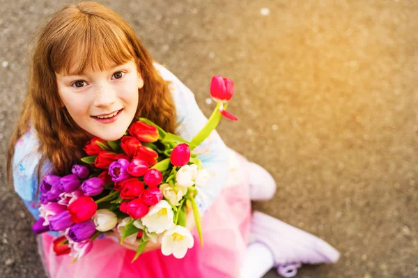 Retrato al aire libre de una niña dulce con gran ramo de tulipanes coloridos —  Fotos de Stock