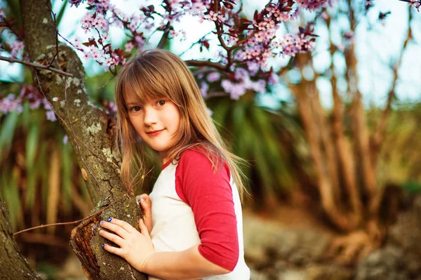 Petite fille dans le jardin de printemps au coucher du soleil — Photo