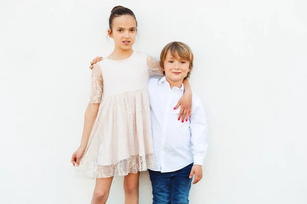 Groep van twee kinderen, meisje en jongen, het dragen van de partij kleding, permanent tegen witte achtergrond — Stockfoto