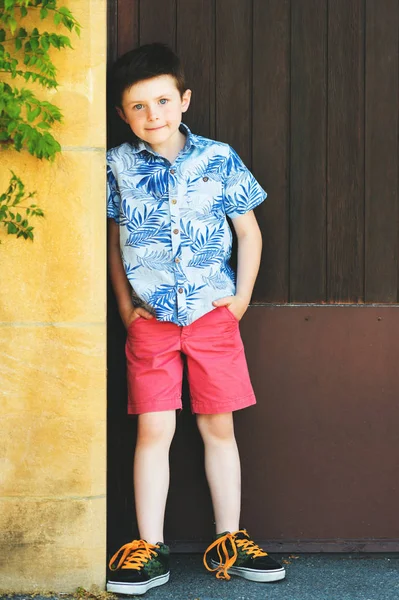 Funny stylish kid boy posing outdoors, wearing blue print shirt — Stock Photo, Image