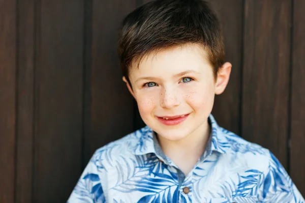 Funny stylish kid boy posing outdoors, wearing blue print shirt — Stock Photo, Image