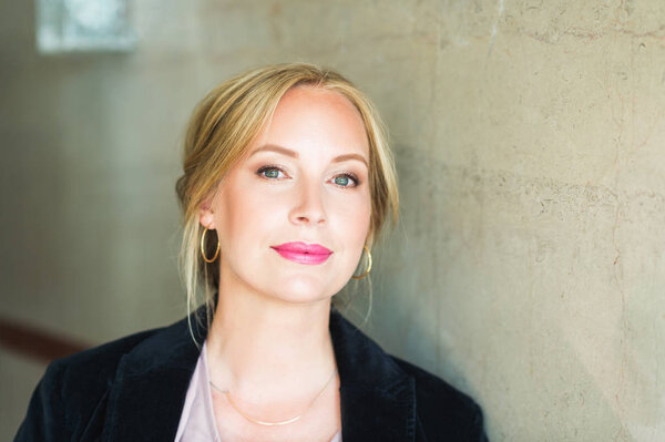 Close up portrait of beautiful blond woman with blue eyes, wearing professional makeup