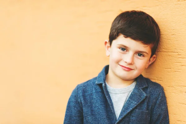 Крупным планом портрет очаровательного 6-летнего мальчика, прислонившегося к стене — стоковое фото