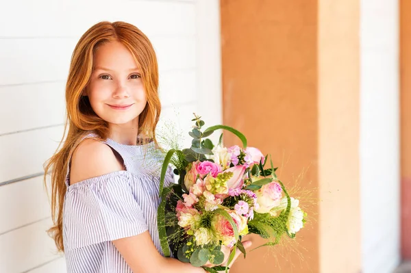 Primer plano retrato de adorable chica de pelo rojo niño sosteniendo gran ramo de flores con rosas —  Fotos de Stock