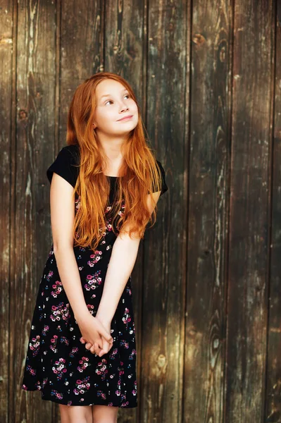 Outdoor fashion portrait of happy red-haired girl, posing against old wooden background — Stock Photo, Image