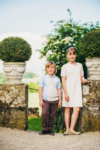 Fashion kids posing in beautiful antique garden, wearing vintage style clothing — Stock Photo, Image