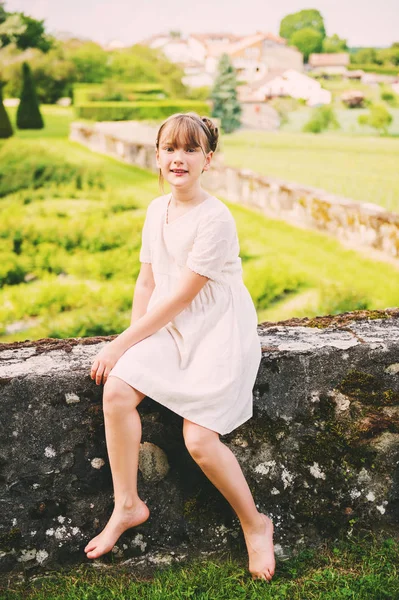 Całkiem mała dziewczynka gra w pięknym ogrodzie w piękny letni dzień, Styl vintage białej sukience — Zdjęcie stockowe