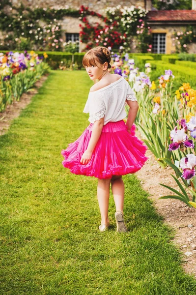 素敵な夏の日に美しい花公園で遊ぶ愛らしい女の子の屋外のポートレート。肩越しに振り返ってファッション子供の女の子が白のブラウスと明るいピンクのチュチュ スカートを着て — ストック写真