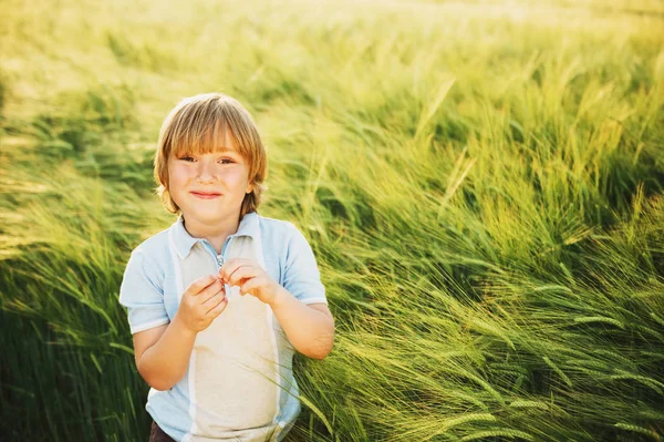 Dulce niño jugando en el campo de trigo al atardecer en verano —  Fotos de Stock