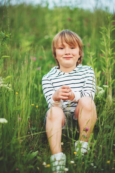 Utendørs portrett av en søt gutt som leker på et jorde om sommeren. – stockfoto