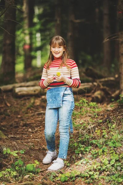 Linda niña disfrutando de bosque de primavera fresca, con overoles de mezclilla y jersey cálido — Foto de Stock
