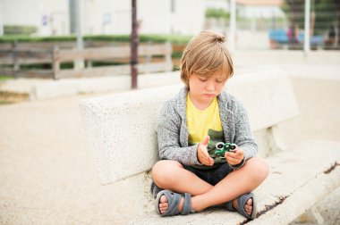 Topluca el spinners ile oynayan çok üzgün çocuk