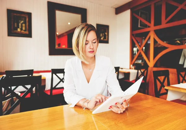 Genç iş kadını bir güzel rahat kafede tablet PC'de çalışma