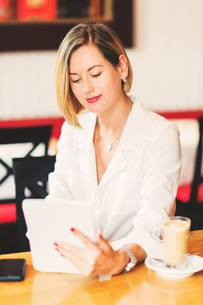 Bella giovane donna d'affari che lavora con tablet pc in una caffetteria — Foto Stock