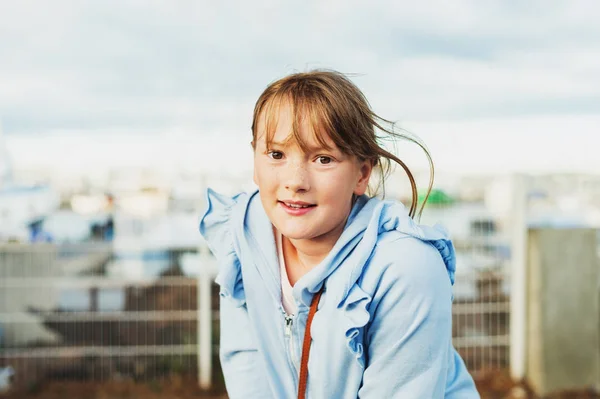 Außenporträt des niedlichen kleinen Mädchens mit blauem Reißverschluss durch Kapuzenpulli — Stockfoto