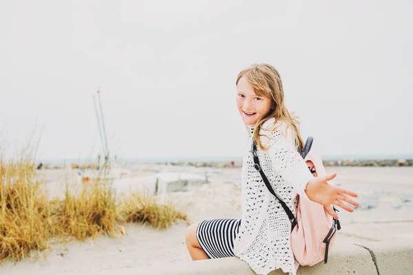 Little girl enjoying summer vacation by the sea, wearing stripe nautical dress and backpack. Image taken in Saintes-Maries-de-la-Mer, capital of Camargue, south of France — Stock Photo, Image