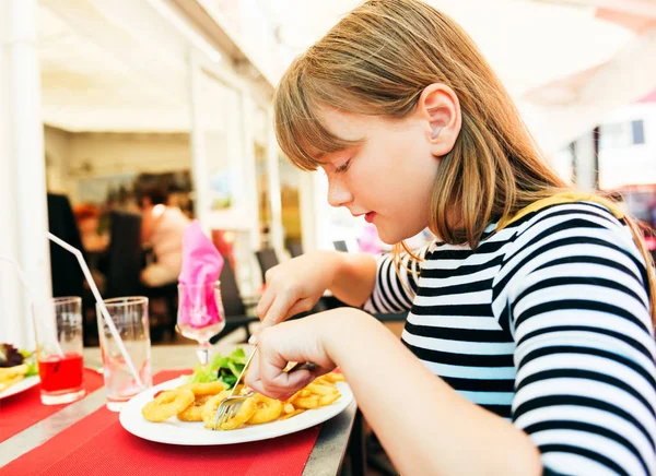 Child eating for lunch calamares a La Romana Fried Squid at restaurant table — Stock Photo, Image