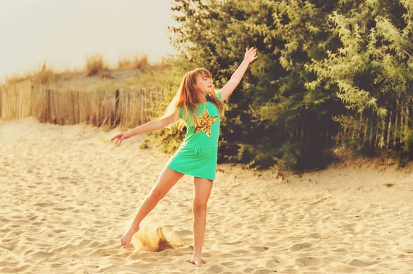 Vackra kid flicka dansa på sandstrand vid havet i solnedgången. Preteen barn njuter av sommarlovet på södra Frankrike — Stockfoto