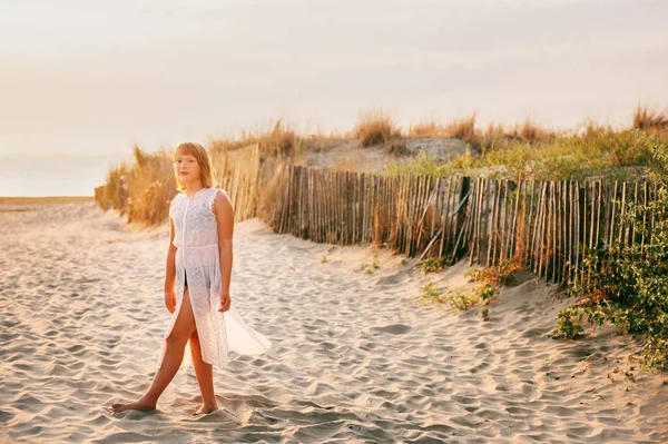 Szép gyerek lány tánc homokos strand a tengerparton naplementekor. Preteen gyermek élvezi a nyaralás a Dél-Franciaország — Stock Fotó