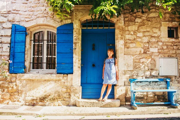 Bella turista bambina per le strade della Provenza, indossando abito blu gingham, occhiali da sole e zaino. Viaggia con il concetto di bambini. Immagine scattata ad Arles, Francia — Foto Stock