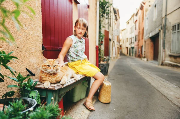 Sevimli küçük kız dışında tüylü zencefil kedi ile oynarken. Valensole, Alpes-de-Haute-Provence bölümü, Fransa alınan görüntü