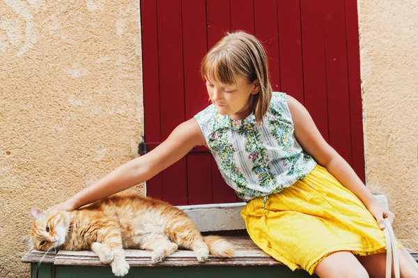 Cute dziewczynka bawi furry imbir cat poza. Zdjęcie zrobione w Valensole, departament Alpes-de-Haute-Provence, Francja — Zdjęcie stockowe