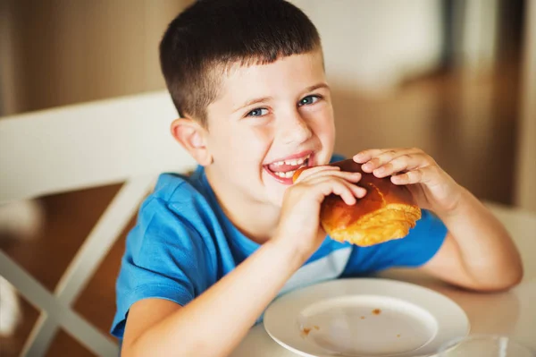 Sweet little boy eating vanilla bread for breakfast — Stock Photo, Image