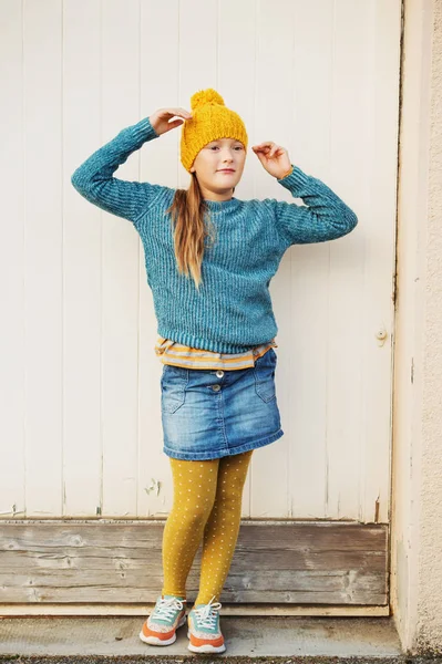 Retrato de moda ao ar livre de linda menina de 9 anos, usando chapéu amarelo, pulôver azul, saia jeans e meia-calça polka dot — Fotografia de Stock