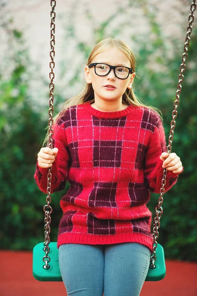 Retrato ao ar livre de uma linda menina de 9 anos usando óculos e pulôver de moda vermelha — Fotografia de Stock