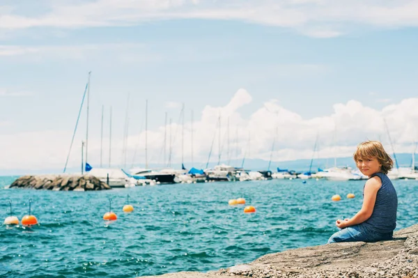 Funny little boy resting by lake Geneva in a small Lutry port, Switzerland — Stock Photo, Image