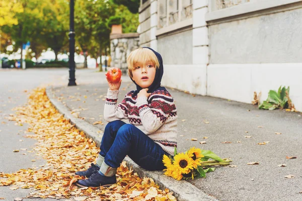 Podzimní portrét roztomilý blonďatý chlapeček 4 roky staré, teplý svetr s kapucí, tmavě modré džíny a modré boty, ale napřed a kytice žlutých slunečnic — Stock fotografie