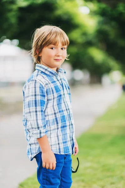 Retrato de moda al aire libre de lindo niño de 6 años con camisa y pantalones casuales a cuadros azules —  Fotos de Stock