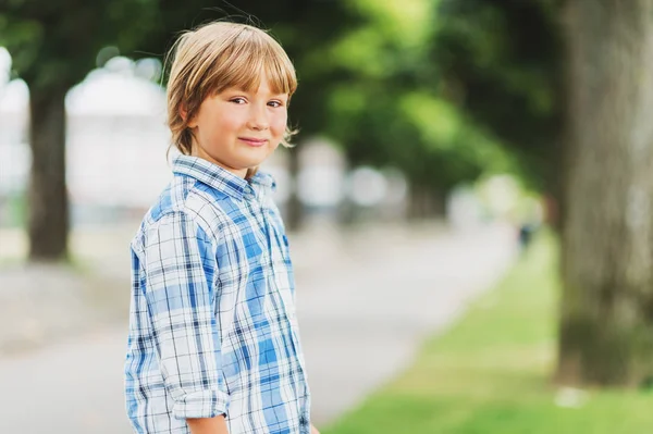 Retrato de moda ao ar livre de bonito menino de 6 anos de idade vestindo camisa casual xadrez azul — Fotografia de Stock