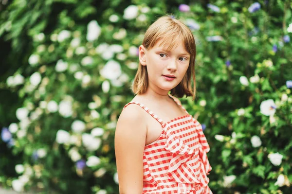 Outdoor portrait of pretty little 9-10 year old girl wearing red gingham dress — Stock Photo, Image