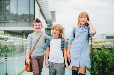 Açık havada poz, sırt çantaları giyen 3 komik schoolkids grubudur. Geri okul kavramı. Çocuklar için moda