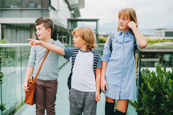 Group of 3 funny schoolkids posing outdoors, wearing backpacks. Back to school concept. Fashion for children — Stock Photo, Image