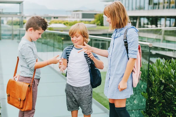 Grupo de 3 niños jugando Rock, papel, juego de tijeras en el patio de la escuela. Concepto de vuelta a la escuela, moda para niños —  Fotos de Stock