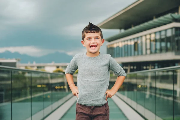 Ritratto all'aperto di un simpatico bambino di 6 anni che indossa un pullover blu. Giovane modella maschile in posa per strada, moda per bambini — Foto Stock