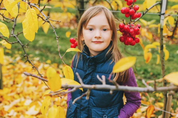 Outdoor portrait of adorable little 5 year old girl in autumn garden, wearing warm blue vest — Stock Photo, Image