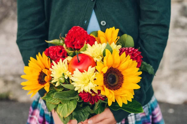 Belo buquê de flores brilhantes e coloridas segurando as mãos da criança — Fotografia de Stock