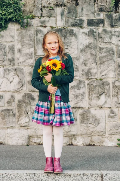Açık güzel buket sonbahar çiçek tutan schoolwear, giyen sevimli küçük bir kız portresi — Stok fotoğraf