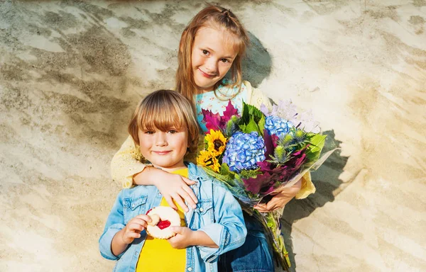 Outdoor-Porträt eines niedlichen kleinen Kinder mit schönem Strauß Herbstblumen. — Stockfoto