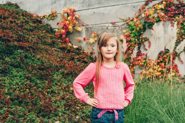 Portrait extérieur de jolie petite fille de 7 ans portant un pull rose. Mode d'automne pour les enfants — Photo