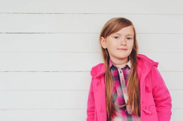 Retrato al aire libre de niña bonita con abrigo rosa, moda de otoño para niños, posando sobre fondo blanco — Foto de Stock